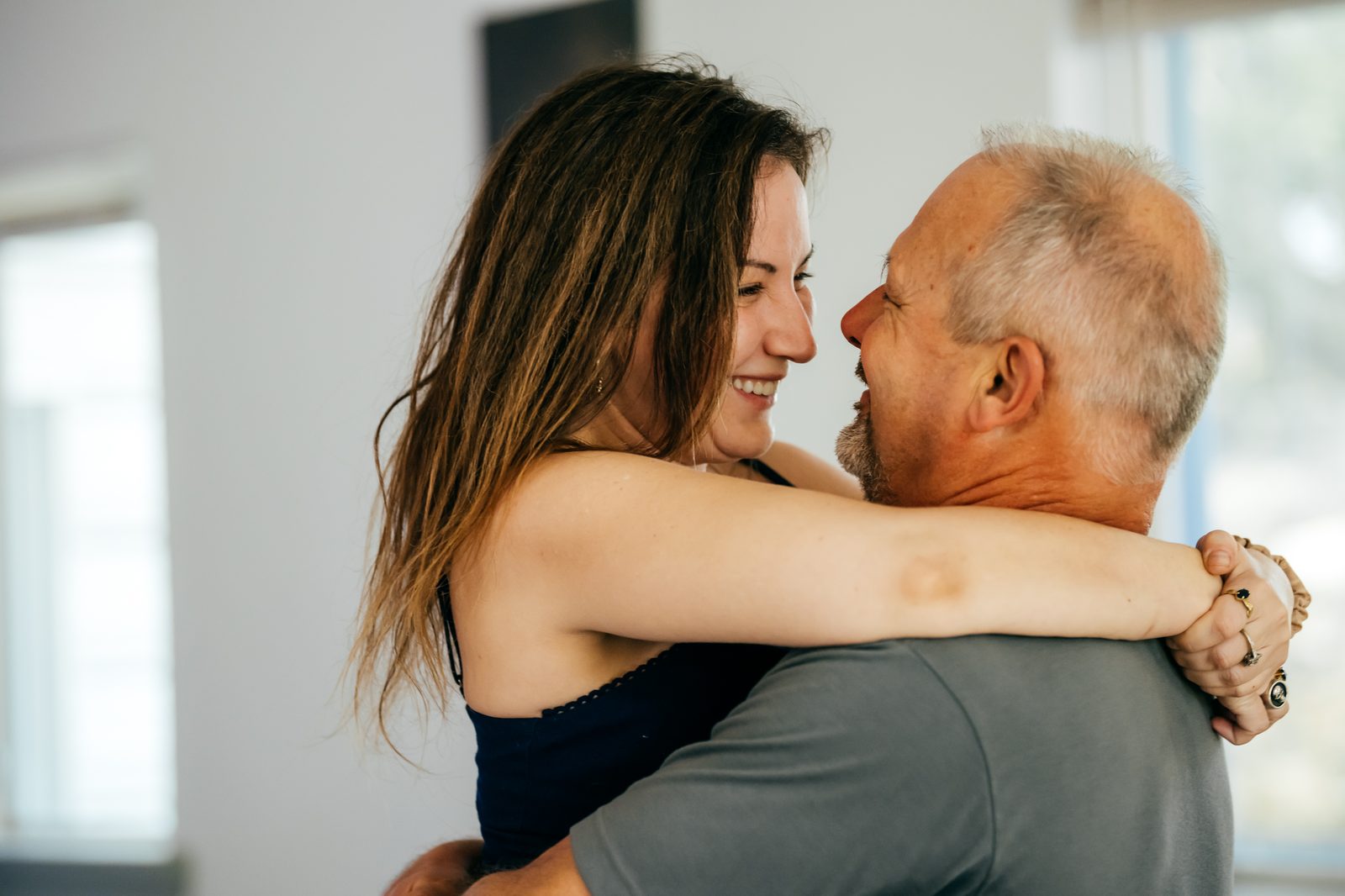 A couple laughing together in close embrace during a workshop practice