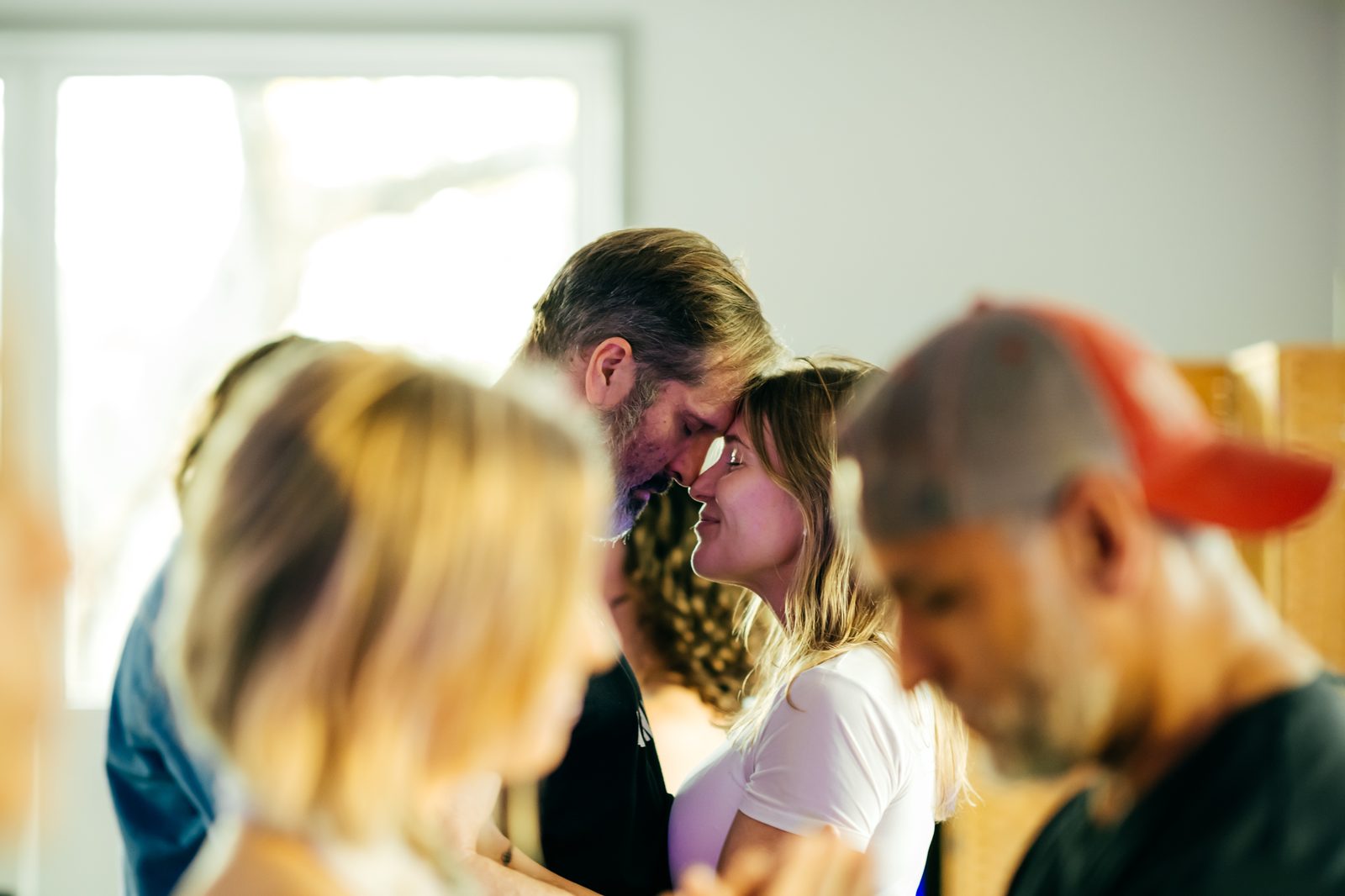 Pick: couple forehead-to-forehead with community around