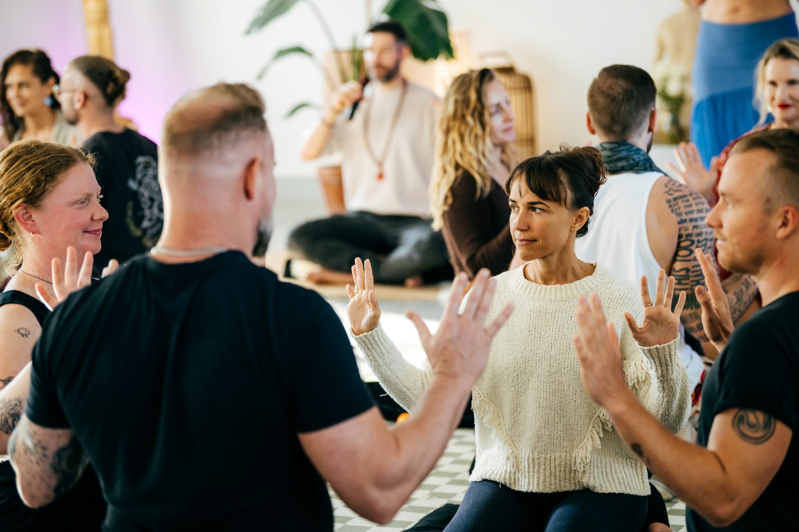 Partners practicing a hands-up mirroring exercise in a workshop circle